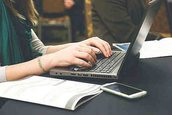 Frau mit Laptop und Smartphone